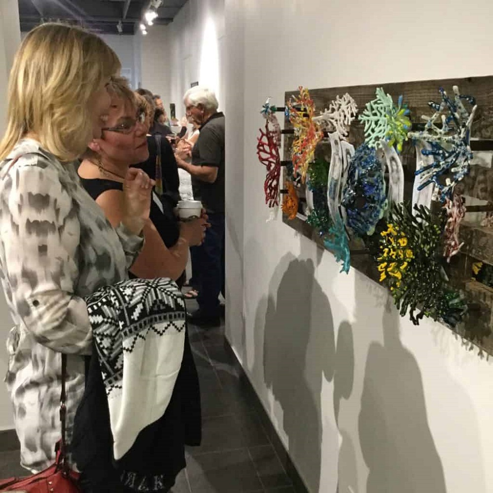 Saskatchewan Craft Council Gallery - Guests enjoying group exhibition, "Colour Outside the Lines" featuring work by member of the Saskatoon Glassworkers' Guild